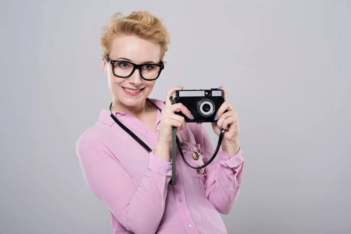 Eine Frau fotografiert mit einer Retro-Kamera.